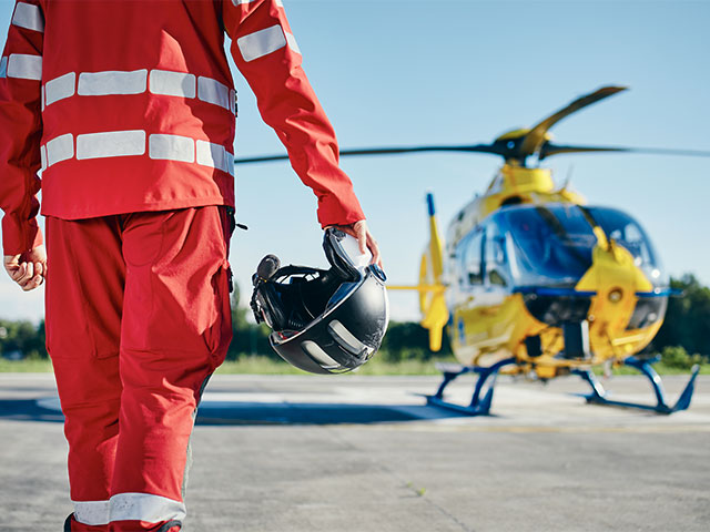 An air ambulance piolt approaching his helicopter.
